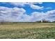 Rolling hills on a lush green property, with bright blue skies and scattered clouds, are visible from this home at 4358 S Alton St, Greenwood Village, CO 80111