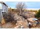 A backyard boasting a stone fire pit, hot tub, and landscaping, creating an inviting outdoor oasis at 9407 E 147Th Pl, Brighton, CO 80602