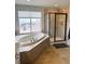 Bathroom with soaking tub with a view and sleek glass enclosed shower at 9407 E 147Th Pl, Brighton, CO 80602