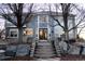 Charming home featuring a stone staircase leading to the front door with beautiful landscaping and mature trees at 9407 E 147Th Pl, Brighton, CO 80602