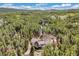 A high altitude aerial of a home with a three car garage situated in a forest at 24 Navajo Trl, Evergreen, CO 80439