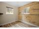 Bedroom features wood-look wall detail, wood floors, white trim, and a window looking out to a wooded landscape at 24 Navajo Trl, Evergreen, CO 80439