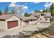 Home exterior featuring a three car garage, large driveway and basketball hoop at 24 Navajo Trl, Evergreen, CO 80439