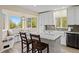 Sunny kitchen nook with table and seating below bright windows, surrounded by white cabinets and granite countertops at 24 Navajo Trl, Evergreen, CO 80439