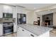 Kitchen featuring an island with stone countertops and dark wood seating, plus stainless appliances and a stone fireplace at 24 Navajo Trl, Evergreen, CO 80439