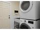 Functional laundry room with stacked washer and dryer, utility sink, and convenient storage solutions at 24 Navajo Trl, Evergreen, CO 80439