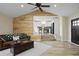 Living room with a brown leather couch, wooden wall, and open access to the white kitchen at 24 Navajo Trl, Evergreen, CO 80439
