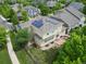 Aerial view of a two-story home with a patio, solar panels, and surrounded by lush greenery and trees at 6690 S Fenton St, Littleton, CO 80123