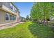 Green backyard with a wooden fence, mature trees, and a small brick patio with room to entertain at 6690 S Fenton St, Littleton, CO 80123