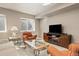 Comfortable basement living area with a television, side tables, and soft, neutral carpeting at 6690 S Fenton St, Littleton, CO 80123