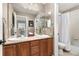 Well-lit bathroom features double sinks, vanity with cabinets, a large mirror and a separate toilet and shower at 6690 S Fenton St, Littleton, CO 80123