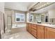 Luxurious bathroom with soaking tub, walk-in shower, dual sinks, and a large vanity mirror at 6690 S Fenton St, Littleton, CO 80123