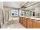 Bright bathroom with a soaking tub, glass shower, double vanity, and tile flooring at 6690 S Fenton St, Littleton, CO 80123