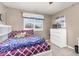 Comfortable bedroom with plush bedding, a bright window, and dresser at 6690 S Fenton St, Littleton, CO 80123