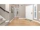 Inviting foyer with hardwood floors, neutral walls, and a view into the downstairs bathroom at 6690 S Fenton St, Littleton, CO 80123