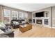 Cozy living room with a fireplace, a large window, hardwood floors, and comfortable leather seating at 6690 S Fenton St, Littleton, CO 80123