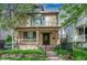 Charming two-story home featuring a covered front porch, black iron fence, and well-maintained lawn at 433 N Ogden St, Denver, CO 80218