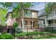 Charming two-story home featuring a covered front porch, black iron fence, and well-maintained lawn at 433 N Ogden St, Denver, CO 80218