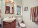 Bathroom featuring a sink with wood vanity, toilet, custom mirror and blue walls at 845 Urban St, Lakewood, CO 80401