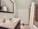 Cozy bathroom featuring a vanity, toilet, and shower/tub combination with tile surround at 845 Urban St, Lakewood, CO 80401