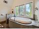 Bathroom featuring a soaking tub with jets, mosaic tile, and natural light from windows at 845 Urban St, Lakewood, CO 80401