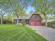 Inviting two-story home with a manicured lawn and a two-car red garage at 845 Urban St, Lakewood, CO 80401