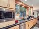 Well-equipped kitchen with stainless steel microwave, ample counter space, and light wood cabinetry at 845 Urban St, Lakewood, CO 80401