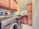 Functional laundry room with stainless steel washer/dryer, storage cabinets, and countertop at 845 Urban St, Lakewood, CO 80401
