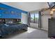 Comfortable bedroom with blue accent wall, built-in bookcase, and large window with backyard view at 12513 Alcott St, Broomfield, CO 80020