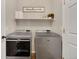 Modern laundry room featuring new washer and dryer, shelving, and natural light at 12513 Alcott St, Broomfield, CO 80020