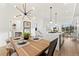 Elegant dining room with a wood table and chairs, modern lighting, and an open view to the kitchen at 2144 Applewood Dr, Lakewood, CO 80215