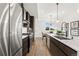 Stylish kitchen with stainless steel appliances, dark wood cabinets, a kitchen island, and sleek countertops at 2144 Applewood Dr, Lakewood, CO 80215