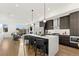 Open-concept kitchen features a large island with seating, stainless steel appliances, and dark wood cabinetry at 2144 Applewood Dr, Lakewood, CO 80215