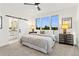 Bright main bedroom with large windows and a sliding barn door to the ensuite bathroom at 2144 Applewood Dr, Lakewood, CO 80215