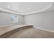 Well lit basement has carpeted platforms for seating or staging, and a window providing natural light at 14620 Prairie Sky Ln, Broomfield, CO 80023