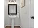 Powder room with a pedestal sink, black framed mirror, and stylish lighting fixture at 14620 Prairie Sky Ln, Broomfield, CO 80023