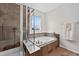 Modern bathroom with a soaking tub next to a glass-enclosed shower and a window for natural light at 14620 Prairie Sky Ln, Broomfield, CO 80023