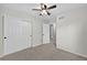 A bedroom is brightened by a ceiling fan, and it features a neutral color palette with white closet doors at 14620 Prairie Sky Ln, Broomfield, CO 80023