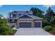 Beautiful two-story home featuring a stone facade and a three-car garage, with attractive landscaping at 14620 Prairie Sky Ln, Broomfield, CO 80023