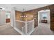 Hallway with stone accent wall and white railing, leading to upstairs rooms at 14620 Prairie Sky Ln, Broomfield, CO 80023