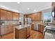 Spacious kitchen with wood floors, an island, granite counters, stainless appliances, and wood cabinets at 14620 Prairie Sky Ln, Broomfield, CO 80023