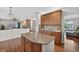 Kitchen island with granite counters and wood cabinets, flowing into an open-concept living area at 14620 Prairie Sky Ln, Broomfield, CO 80023