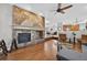Open-concept living room featuring a stone fireplace, hardwood floors, and modern decor at 14620 Prairie Sky Ln, Broomfield, CO 80023
