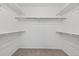 Neutral carpeted walk-in closet featuring shelving and a clothes rod for organized storage solutions at 14620 Prairie Sky Ln, Broomfield, CO 80023