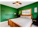 Comfortable bedroom featuring a wooden bed frame, green colored walls, and a ceiling fan at 6895 Big Horn Trl, Littleton, CO 80125