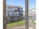 View from private balcony with metal railing, overlooking green space and nearby townhomes at 8751 Pearl St # J3, Thornton, CO 80229
