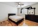 Neutral bedroom features a ceiling fan, large window, dark dresser, and hardwood floors at 8751 Pearl St # J3, Thornton, CO 80229