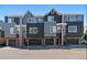 Exterior shot of three townhomes with two-car garages and gray-blue siding, showing symmetry and clean design at 8751 Pearl St # J3, Thornton, CO 80229