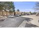 Community exterior showcasing multiple units, ample parking, and mature trees at 4400 S Quebec St # 107, Denver, CO 80237