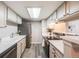 Efficient kitchen features stainless steel appliances, white cabinets, and a bright skylight at 4400 S Quebec St # 107, Denver, CO 80237